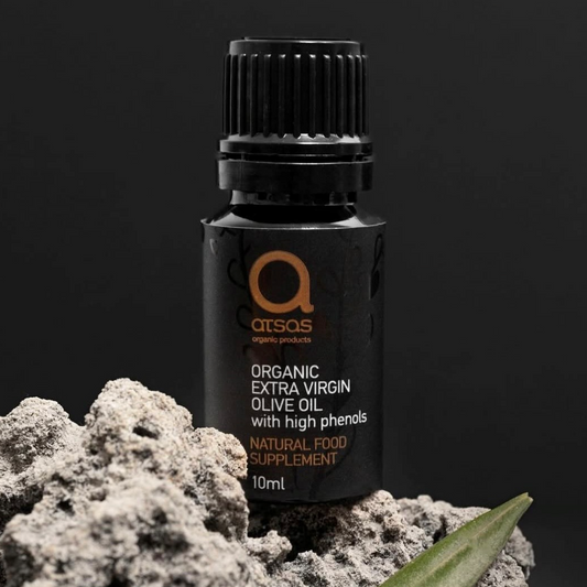 Black 10 ml bottle of Atsas organic extra virgin olive oil with a leaf on a dark background