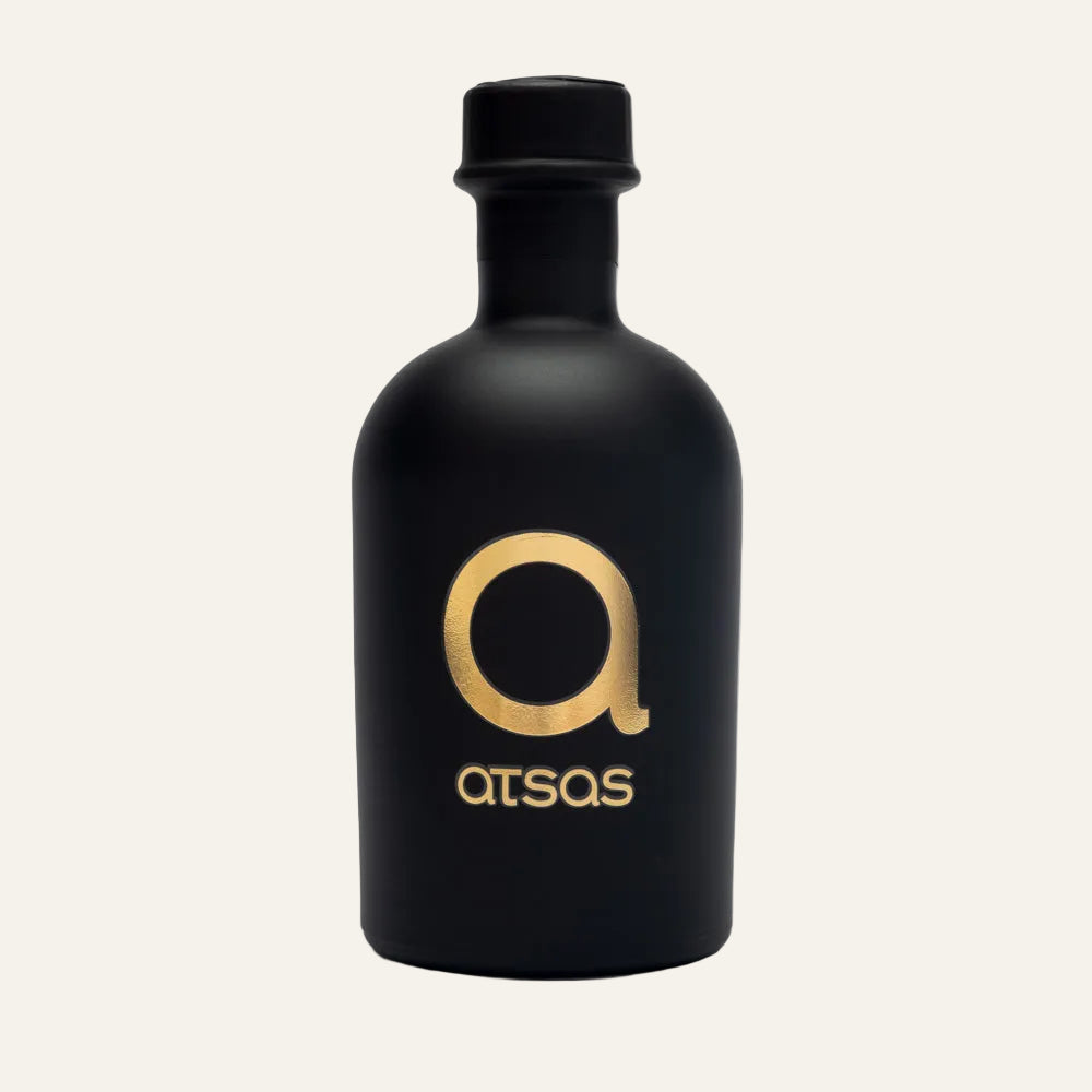 Black bottle of ATSAS Gold Blend olive oil with gold logo and text on a white background