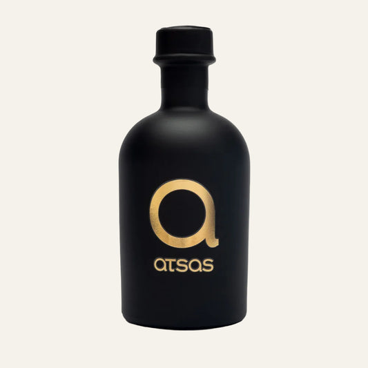Black bottle of ATSAS Gold Blend olive oil with gold logo and text on a white background
