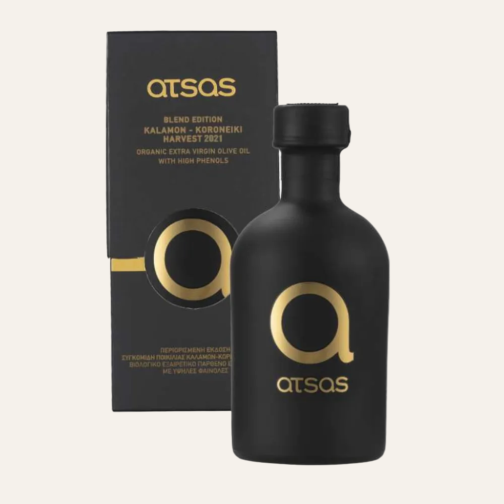 Black organic extra virgin olive oil bottle with gold logo and 'ATSAS' branding next to a black box also featuring the brand.