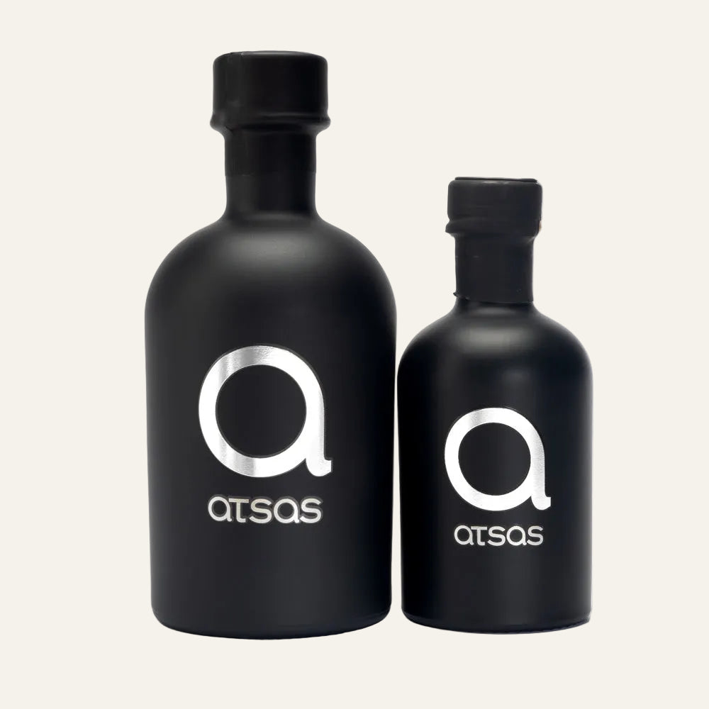 Two black bottles with 'atsas' logo on a white background