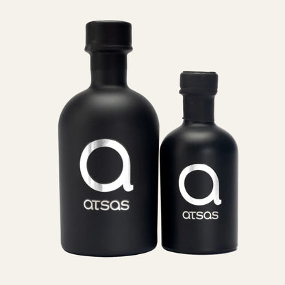 Two black bottles with 'atsas' logo on a white background