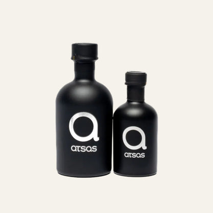 Two black bottles with 'atsas' logo on a plain background