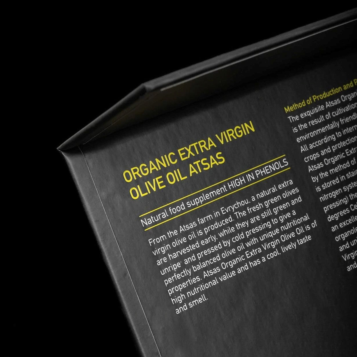 Close-up of a label for Atsas organic extra virgin olive oil with text on a black background.