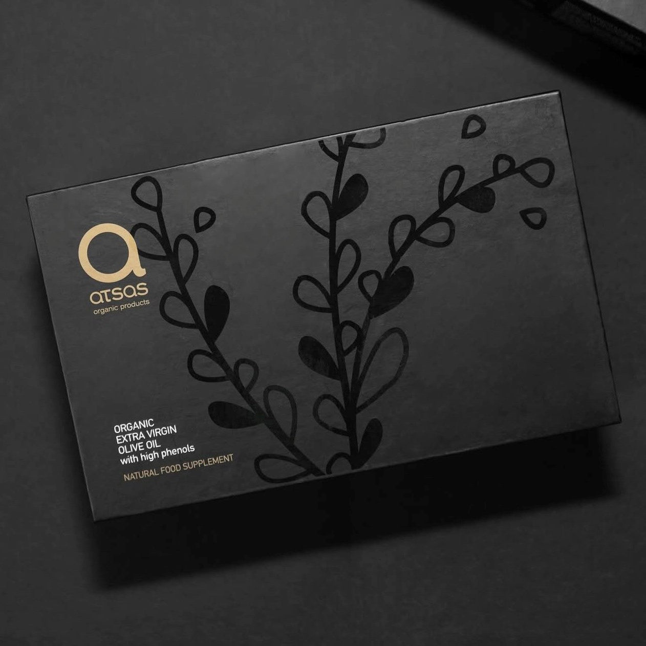 ATSAS organic EVOO black packaging with brand logo and leaf design on a dark background